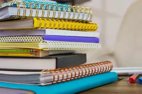 Carnets à spirale et crayons disposés sur une table